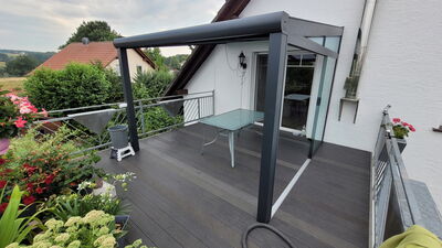 Terrassenüberdachung mit Schiebetüren montiert auf einem Balkon