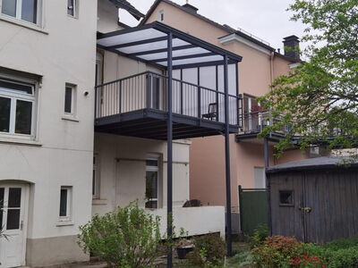 Sicht auf einen Anbaubalkon welcher zusätzlich mit einer Balkonüberdachung versehen ist